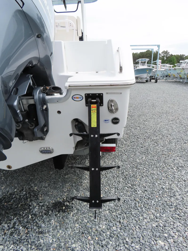 Slide: The Image of 2023 Sea Hunt Gamefish 25 boat stern with motor and ladder on gravel. - 6