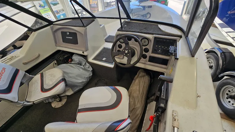 Slide: The Image of Interior of a 2000 Warrior 1898 DC boat, featuring steering wheel and seating. - 13