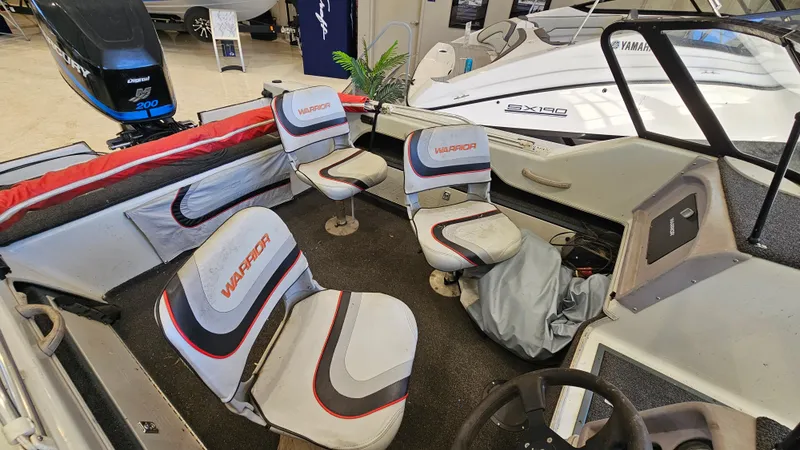 Slide: The Image of Interior of a 2000 Warrior 1898 DC boat with seating and steering wheel. - 14