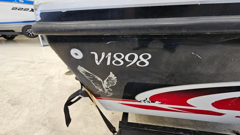 Slide: The Image of Side view of a 2000 Warrior 1898 DC boat with eagle decal and V1898 marking. - 16