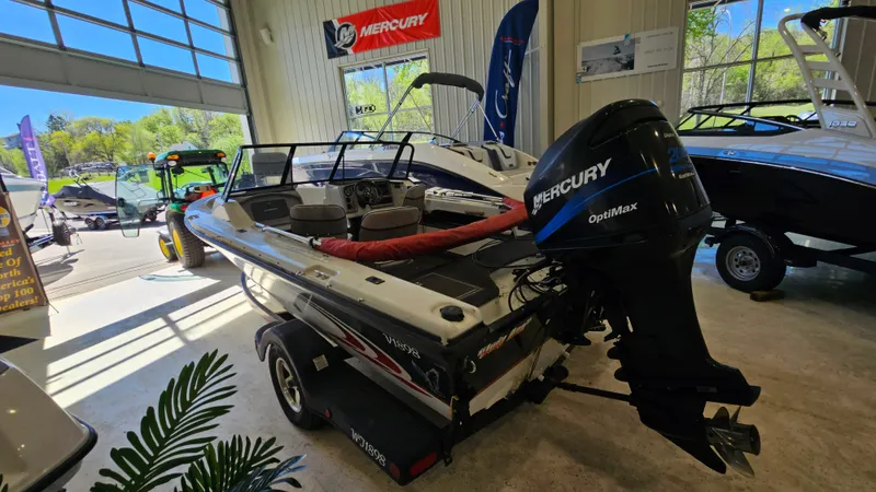 Slide: The Image of Boat showroom featuring a 2000 Warrior 1898 DC with Mercury OptiMax engine. - 2