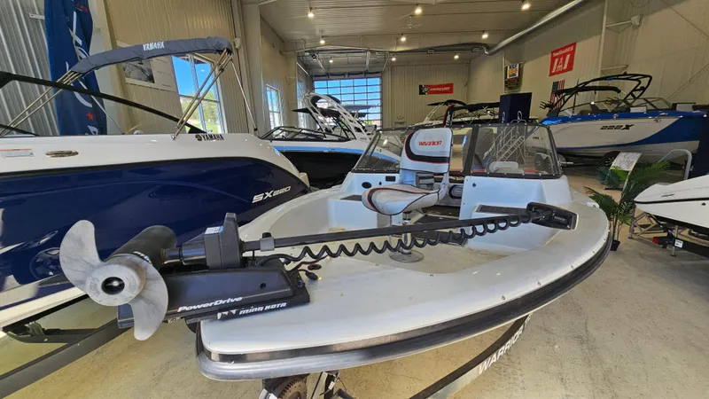 Slide: The Image of 2000 Warrior 1898 DC boat in showroom, featuring trolling motor and modern design. - 6
