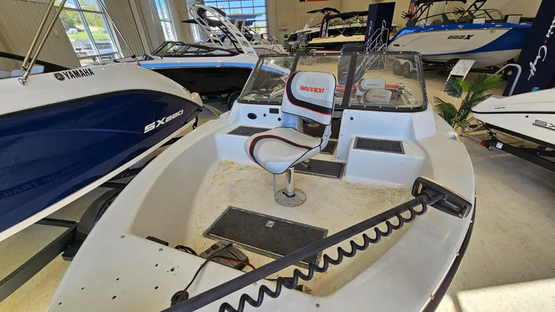 Slide: The Image of 2000 Warrior 1898 DC boat interior with seating and control panel in showroom. - 7