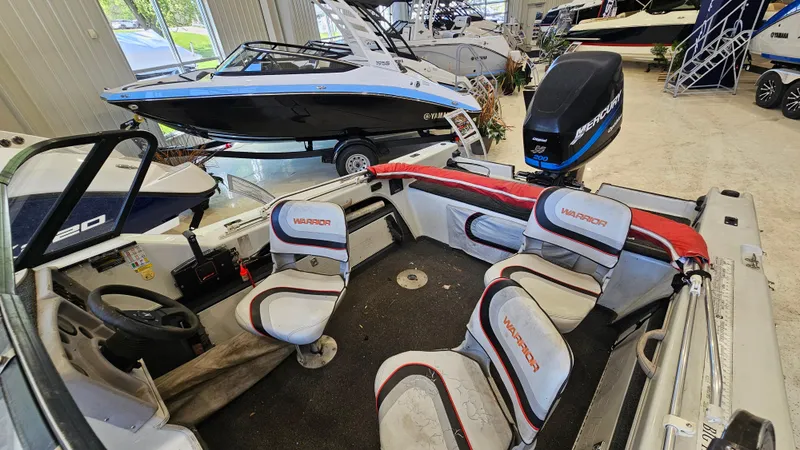 Slide: The Image of Interior of a 2000 Warrior 1898 DC boat with seating and motor in showroom. - 8