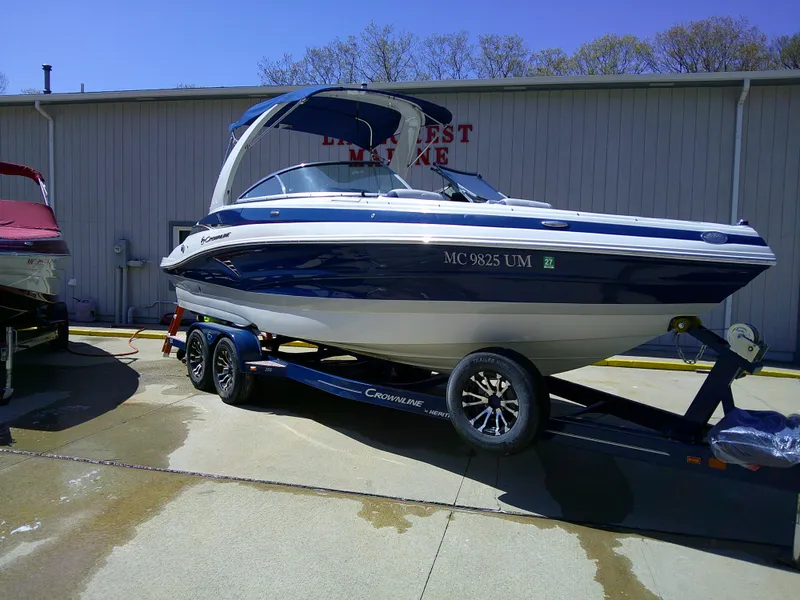 Slide: The Image of 2021 Crownline 255 SS boat on trailer, parked outside a marine facility. - 1