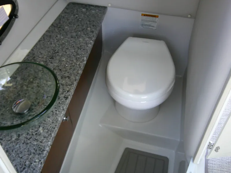 Slide: The Image of 2021 Crownline 255 SS boat bathroom with modern toilet and granite countertop. - 16