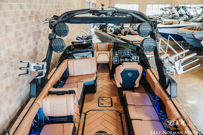 Slide: The Image of 2023 Malibu 26 LSV boat interior with tan seating and advanced dashboard at Lake Norman Marina. - 13