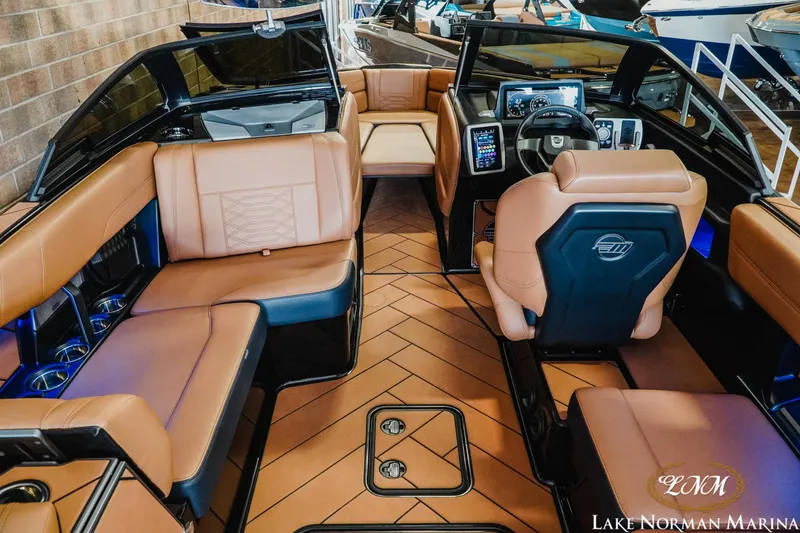 Slide: The Image of 2023 Malibu 26 LSV boat interior with luxurious tan seating and modern dashboard. - 15