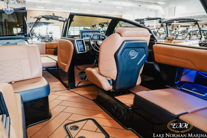 Slide: The Image of Luxurious interior of 2023 Malibu 26 LSV boat with tan leather seating and modern dashboard. - 16