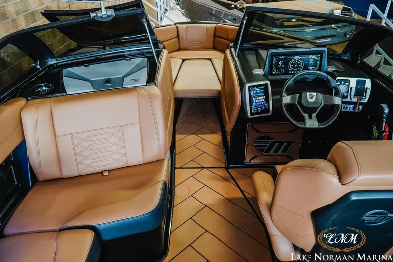 Slide: The Image of 2023 Malibu 26 LSV boat interior with tan leather seats and modern dashboard. - 21