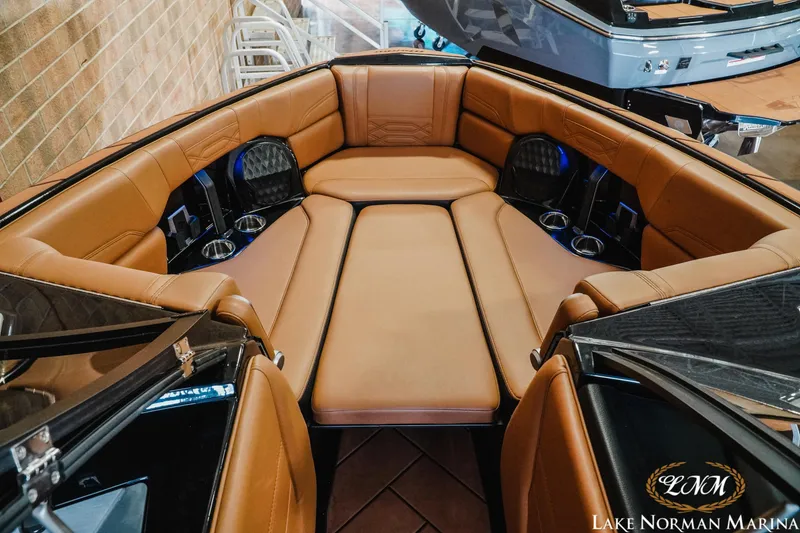 Slide: The Image of 2023 Malibu 26 LSV boat interior with luxurious tan seating and cup holders. - 24