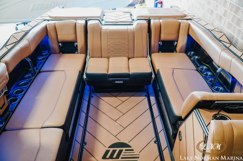 Slide: The Image of Luxurious interior of 2023 Malibu 26 LSV boat with tan seating and cup holders. - 27