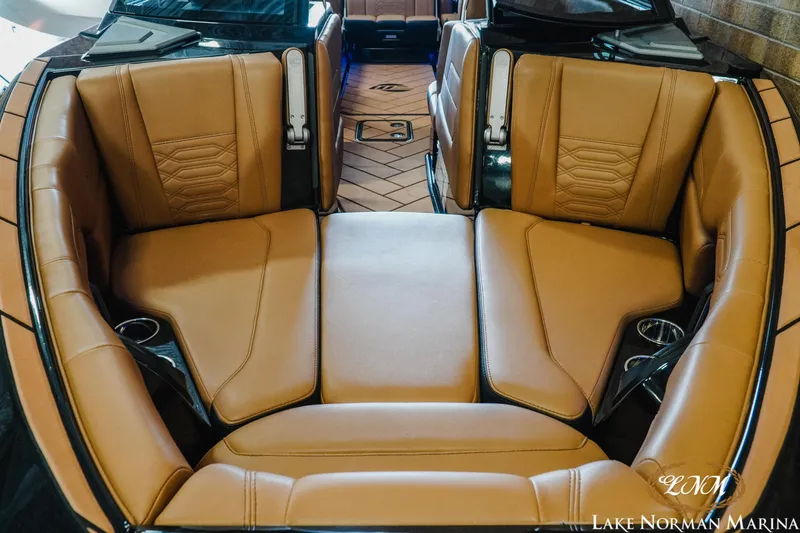 Slide: The Image of 2023 Malibu 26 LSV boat interior with tan leather seating and cup holders. - 5