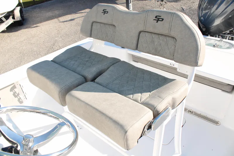 Slide: The Image of 2024 Sea Pro 250 Bay boat seating with gray cushioned seats and steering wheel. - 22