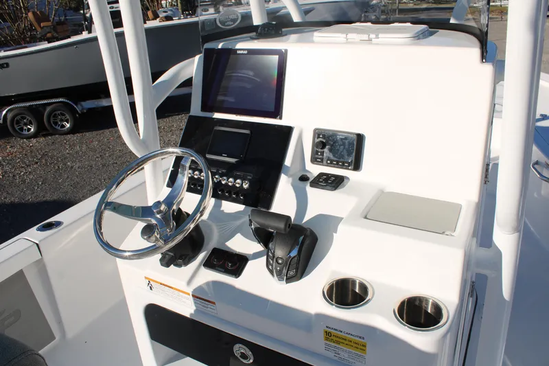 Slide: The Image of 2024 Sea Pro 250 Bay boat console with steering wheel and navigation controls. - 26