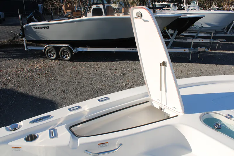 Slide: The Image of 2024 Sea Pro 250 Bay boat with open storage compartment, parked on a trailer. - 37