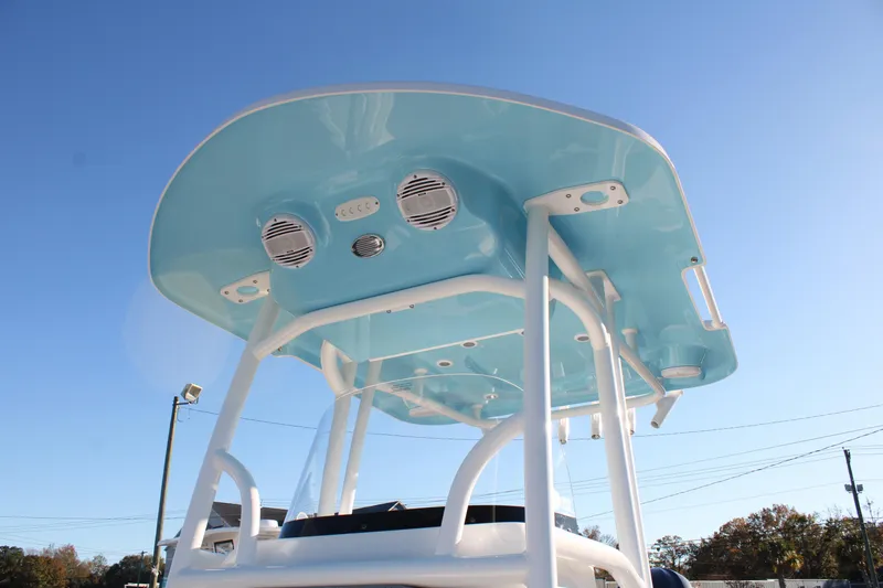 Slide: The Image of 2024 Sea Pro 250 Bay boat with blue T-top and speakers, under clear sky. - 39