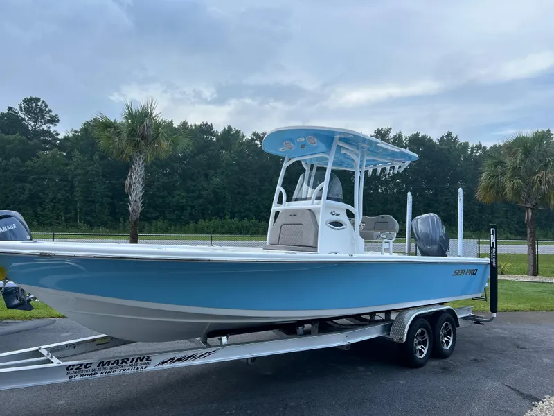 Slide: The Image of 2024 Sea Pro 250 Bay boat on trailer, blue hull, parked outdoors. - 41