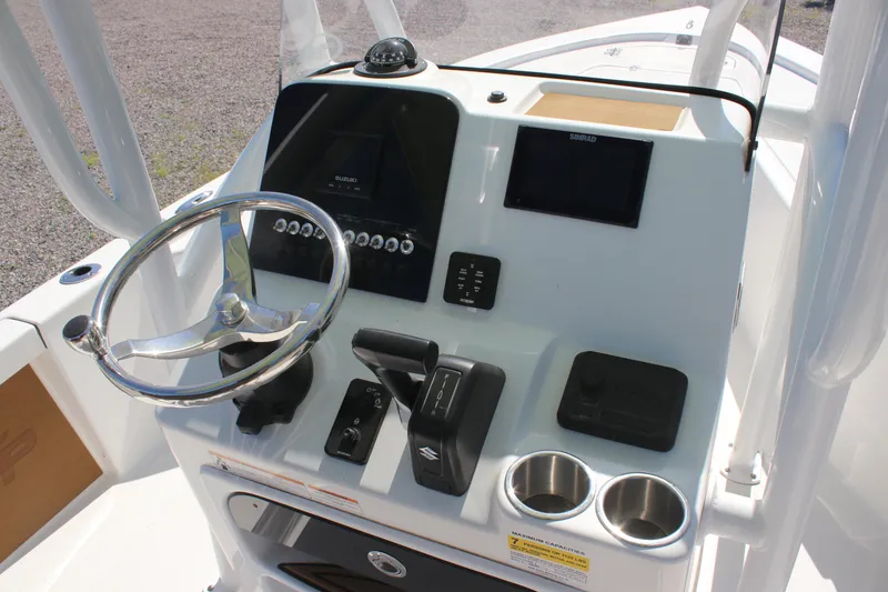 Slide: The Image of 2024 Sea Pro 210 boat console with steering wheel, controls, and cup holders. - 2