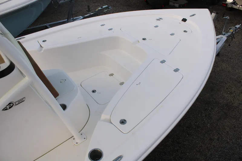 Slide: The Image of 2024 Sea Pro 210 boat deck, featuring storage compartments and sleek design. - 6