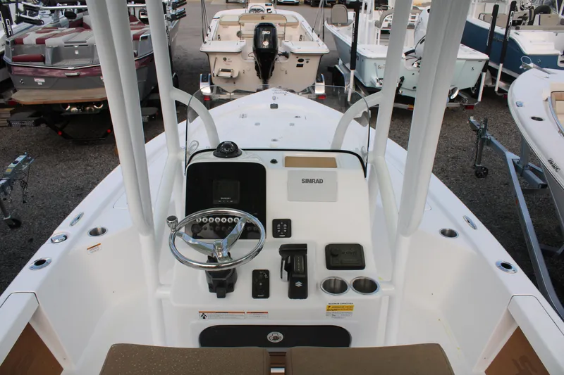 Slide: The Image of 2024 Sea Pro 210 boat dashboard with steering wheel and controls, displayed in a showroom. - 8