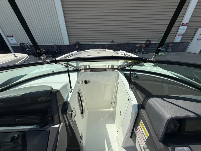 Slide: The Image of 2018 Monterey M-45 boat interior with open cabin door, docked near a warehouse. - 20