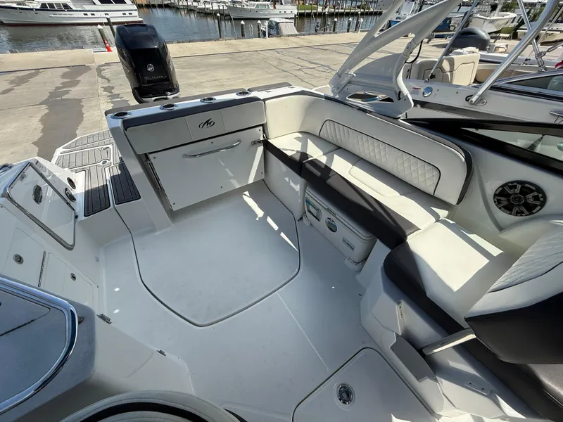 Slide: The Image of 2018 Monterey M-45 boat interior with seating and storage, docked at a marina. - 7