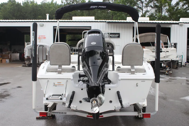 Slide: The Image of 2024 Sea Pro 202 CC boat, rear view, parked at a marina with outboard motor. - 12