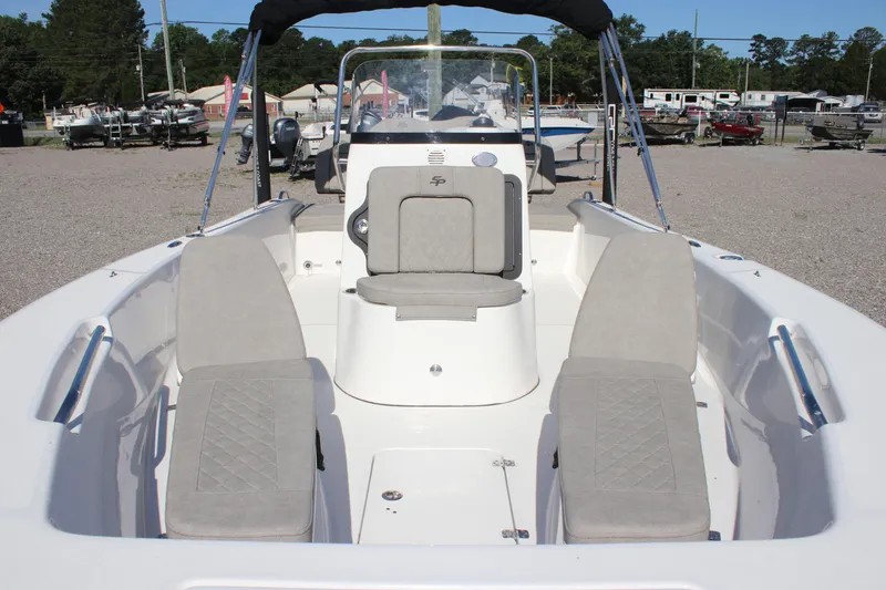 Slide: The Image of 2024 Sea Pro 202 CC boat interior with seating, parked outdoors. - 13