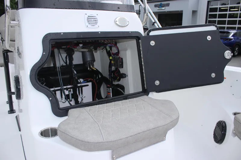 Slide: The Image of 2024 Sea Pro 202 CC boat with open storage compartment and cushioned seat. - 17