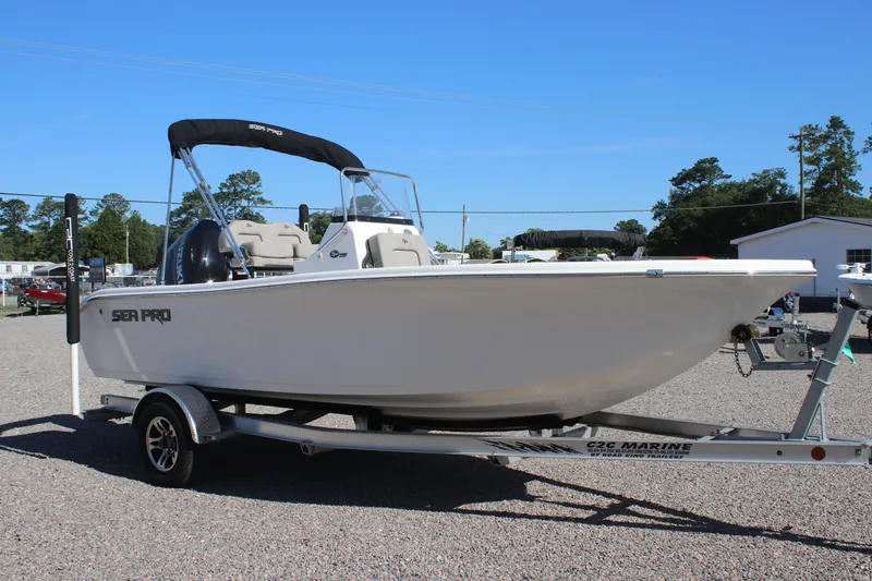 Slide: The Image of 2024 Sea Pro 202 CC boat on trailer, parked outdoors under clear blue sky. - 2