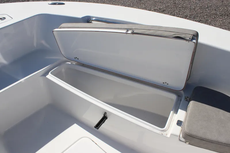 Slide: The Image of 2024 Sea Pro 202 CC boat storage compartment with open lid and cushioned seating. - 7
