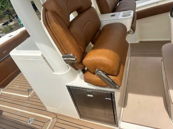 Slide: The Image of 2018 Scout 350 LXF boat interior with brown seating and stainless steel accents. - 13