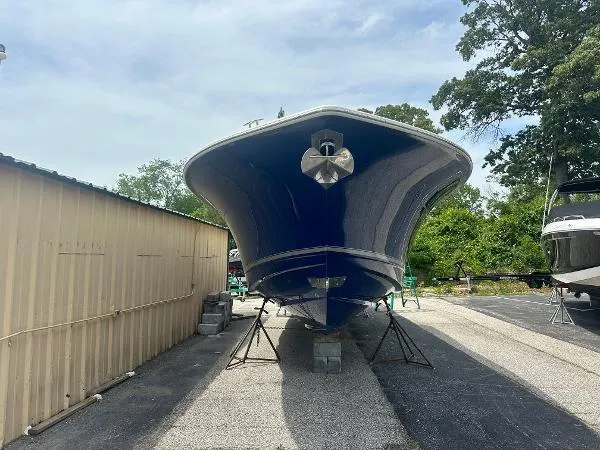 Slide: The Image of 2018 Scout 350 LXF boat on stands, blue hull, outdoor storage. - 2