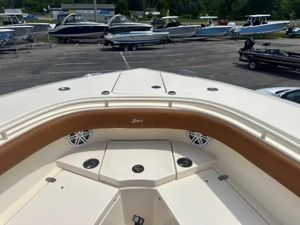 Slide: The Image of 2018 Scout 350 LXF boat interior with brown seating, docked among other boats. - 22