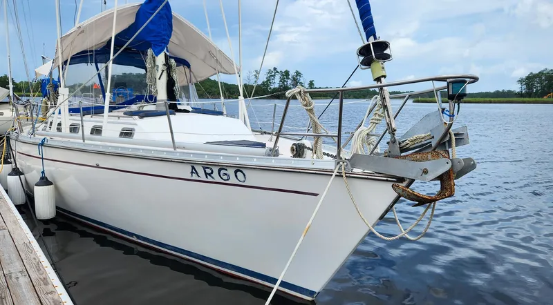 Slide: The Image of 1989 Morgan 44 Center Cockpit sailboat named "Argo" docked by the water. - 1