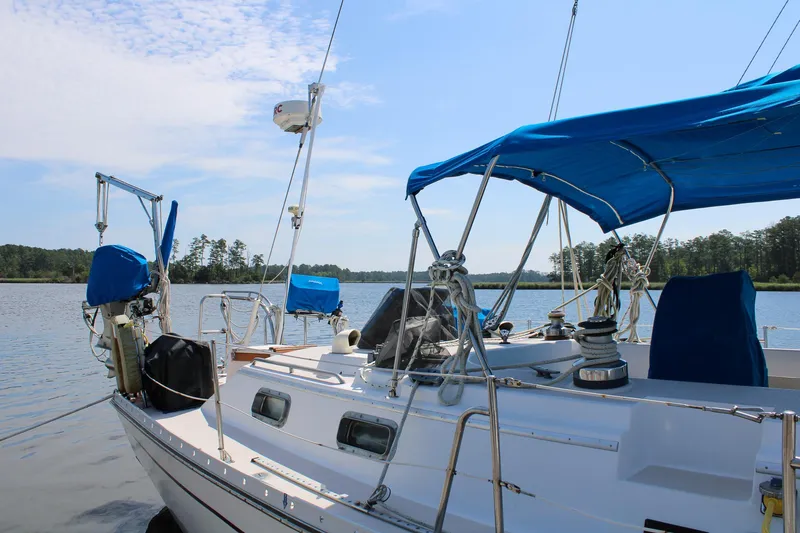 Slide: The Image of 1989 Morgan 44 Center Cockpit sailboat on calm water with blue canopy and clear sky. - 10