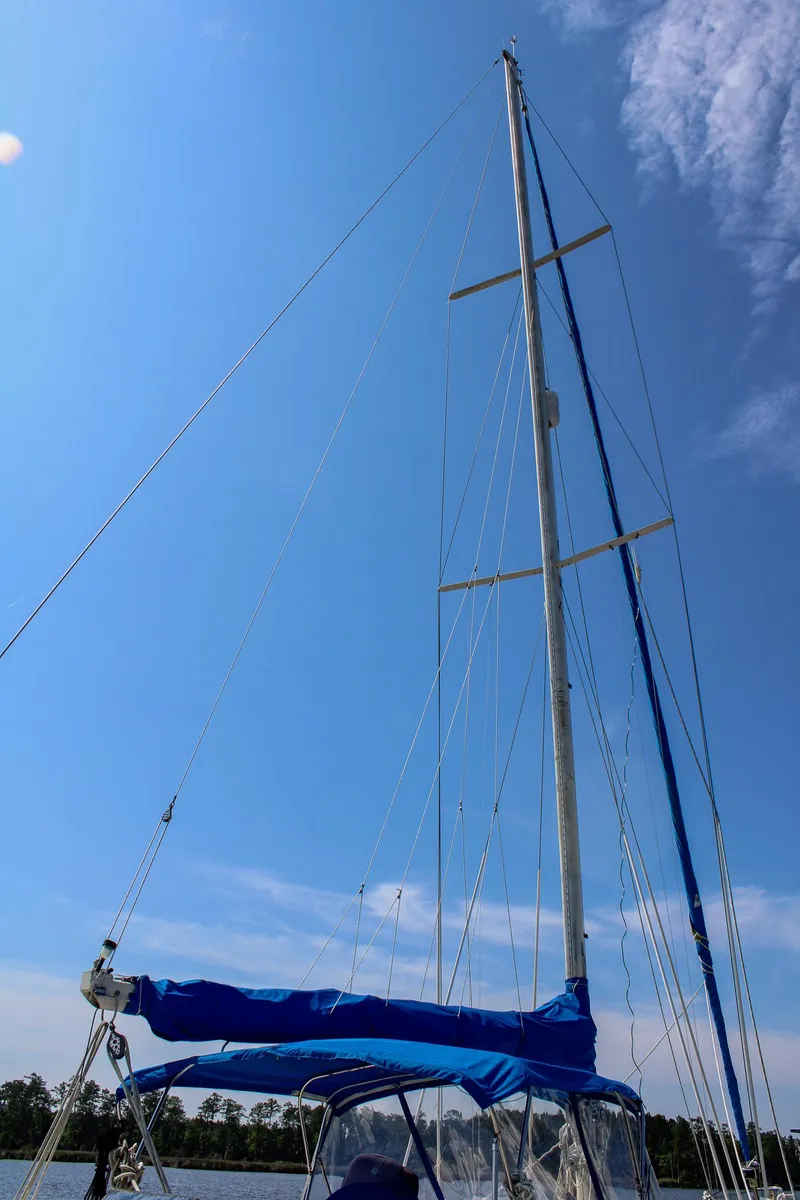 Slide: The Image of 1989 Morgan 44 Center Cockpit sailboat mast against a clear blue sky. - 14