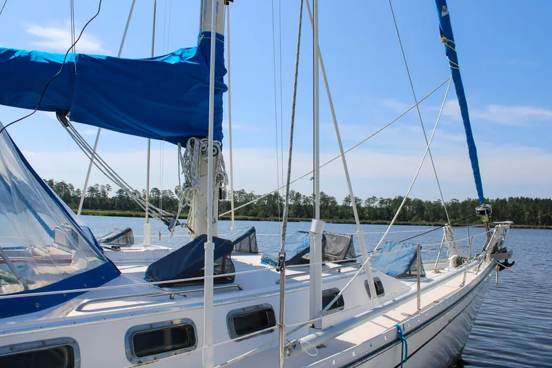 Slide: The Image of 1989 Morgan 44 Center Cockpit sailboat on calm water, blue sky background. - 15