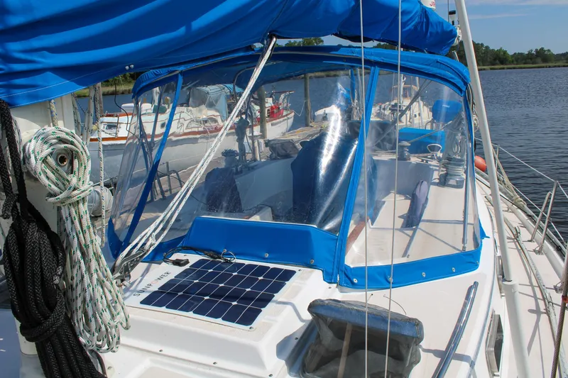 Slide: The Image of 1989 Morgan 44 Center Cockpit sailboat with blue canopy and solar panel on deck. - 16