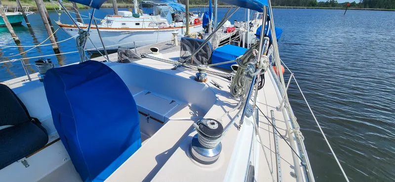 Slide: The Image of 1989 Morgan 44 Center Cockpit sailboat docked, featuring blue covers and serene water backdrop. - 18