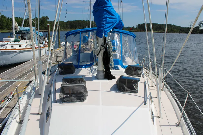 Slide: The Image of 1989 Morgan 44 Center Cockpit sailboat docked on a calm lake. - 19