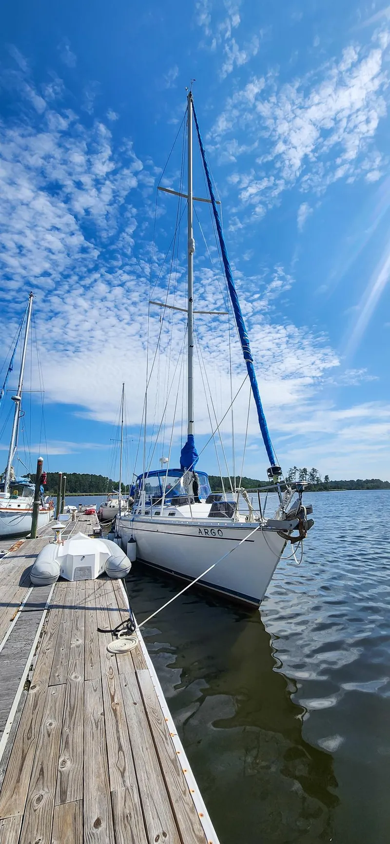 Slide: The Image of 1989 Morgan 44 Center Cockpit sailboat docked under a clear blue sky. - 2