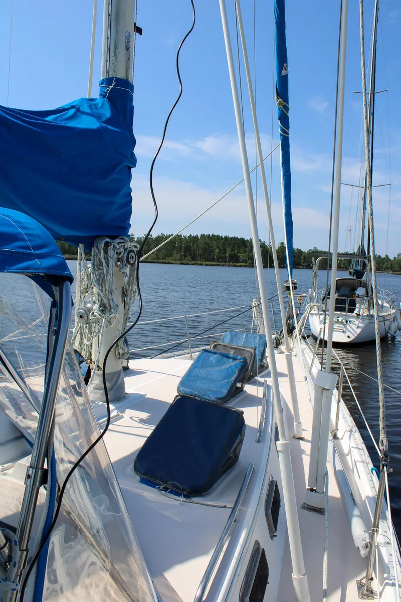 Slide: The Image of 1989 Morgan 44 Center Cockpit sailboat on calm water, featuring blue sails and clear skies. - 23