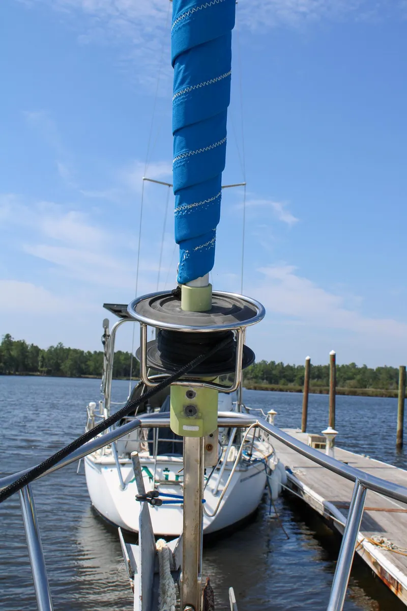 Slide: The Image of 1989 Morgan 44 Center Cockpit sailboat docked, featuring a wrapped sail and clear blue sky. - 24