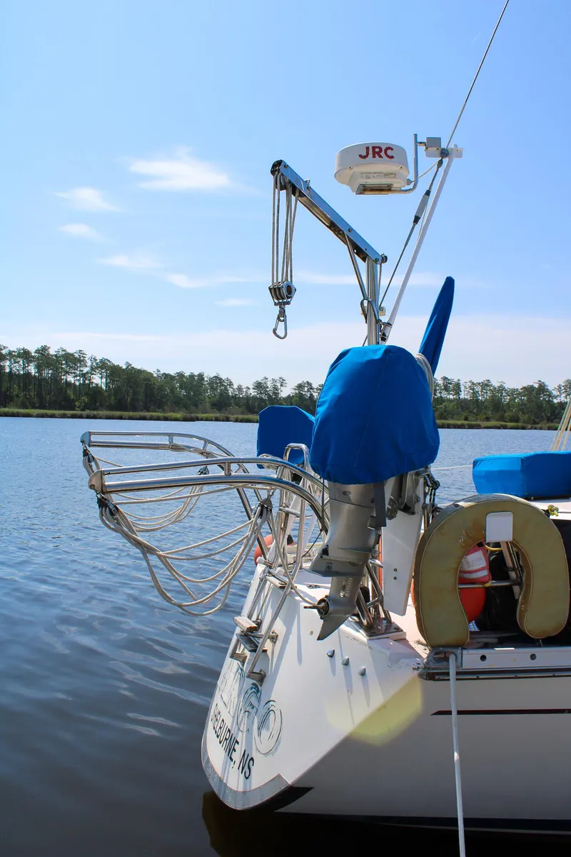 Slide: The Image of 1989 Morgan 44 Center Cockpit sailboat docked on calm water, featuring radar and lifebuoy. - 29