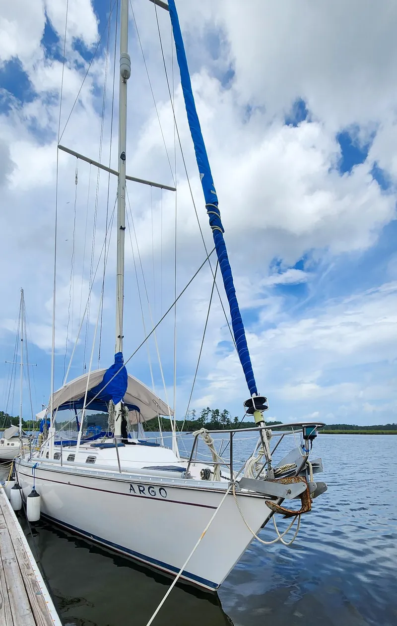 Slide: The Image of 1989 Morgan 44 Center Cockpit sailboat docked under a partly cloudy sky. - 3
