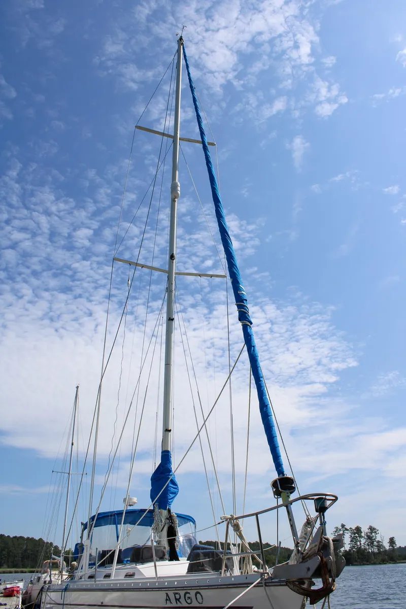 Slide: The Image of 1989 Morgan 44 Center Cockpit sailboat with blue sail cover under a clear sky. - 30