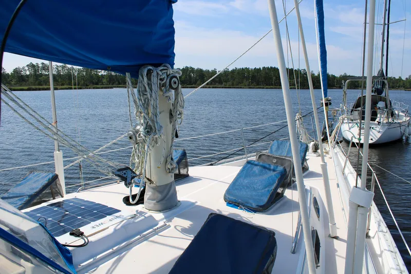 Slide: The Image of 1989 Morgan 44 Center Cockpit sailboat on calm water, featuring blue covers and rigging. - 32