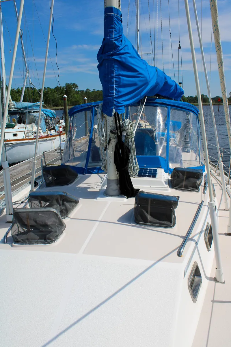Slide: The Image of 1989 Morgan 44 Center Cockpit sailboat with blue sail cover, docked in a marina. - 33